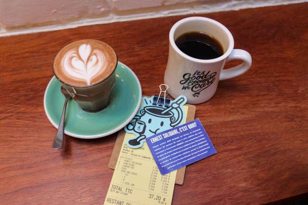 Des cafés dont un avec des beaux dessins en lait.